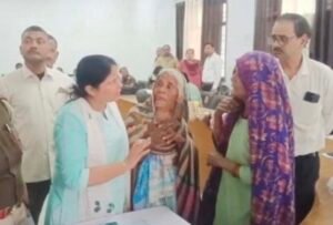 वृद्धा को समझाते अधिकारी 